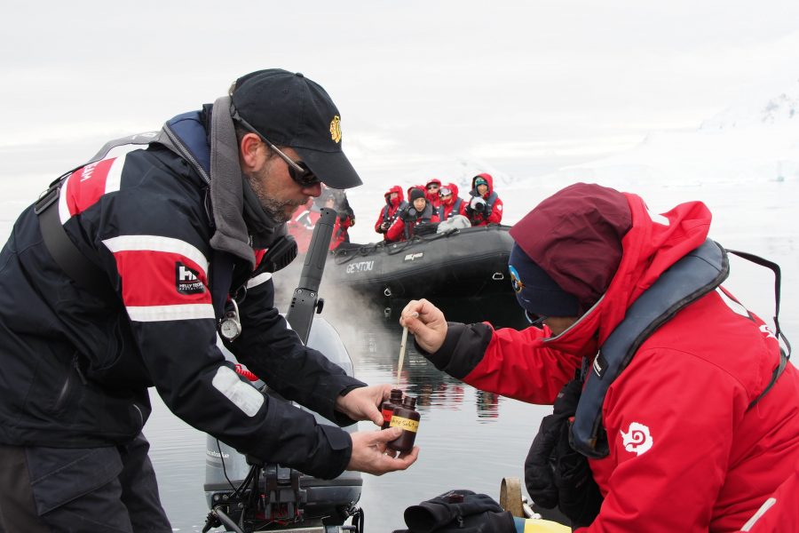 An Antarctic expedition leader assists travellers as part of a Citizen Science programme